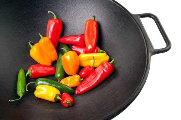 Kleurrijke paprika's in gietijzer wok — Stockfoto
