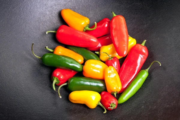 Kleurrijke paprika's in een pot van gietijzer — Stockfoto