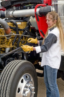 Woman doing pre-trip inspection. clipart