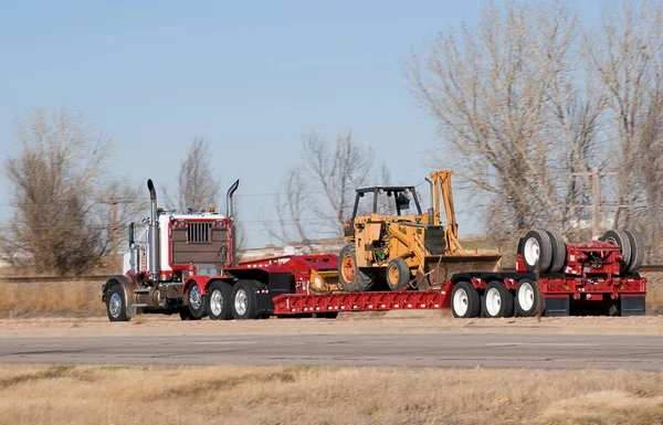 Big rig hauling a side loader — Stock Photo, Image