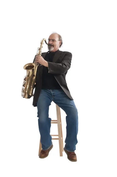 Spela en tenorsaxofon sittande på en pall — Stockfoto