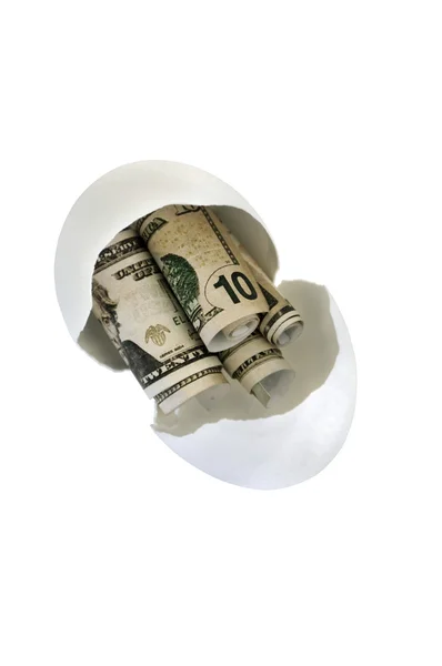 Разбитое яйцо с фальшивыми деньгами — стоковое фото
