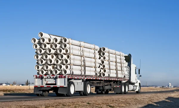 Semi-caminhão com uma carga de tubo de plástico — Fotografia de Stock