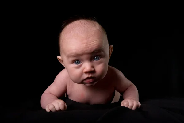 Baby legt sich auf schwarz mit Blick auf dich — Stockfoto