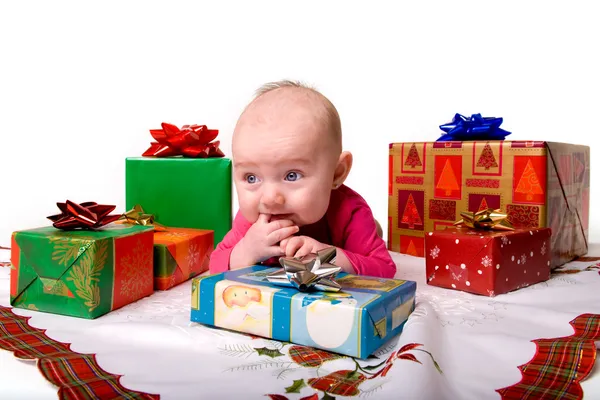Παιδί βρίσκεται μεταξύ δώρα Χριστουγέννων Royalty Free Εικόνες Αρχείου