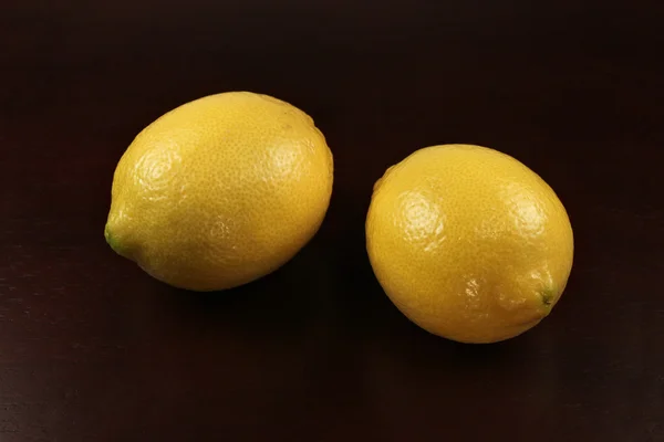 黒い背景に2つのレモンがあり — ストック写真
