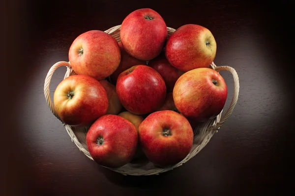 Röda äpplen i en korg — Stockfoto