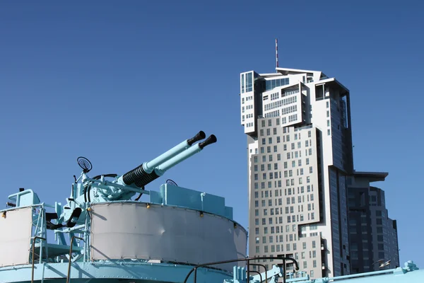 Old naval guns against modern building. — Stock Photo, Image