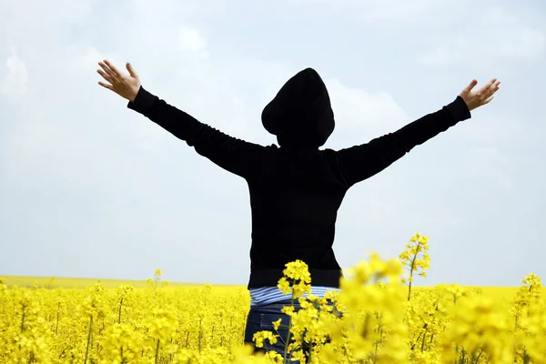 Young girl in a rape field — Stock Photo, Image