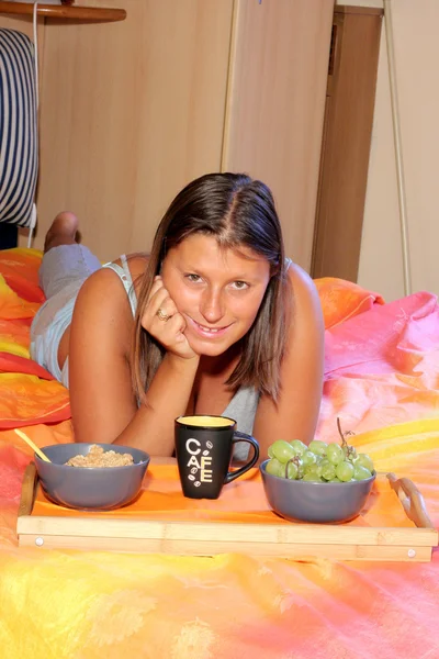 Genç sarışın bir kadın yatakta kahvaltı için — Stok fotoğraf