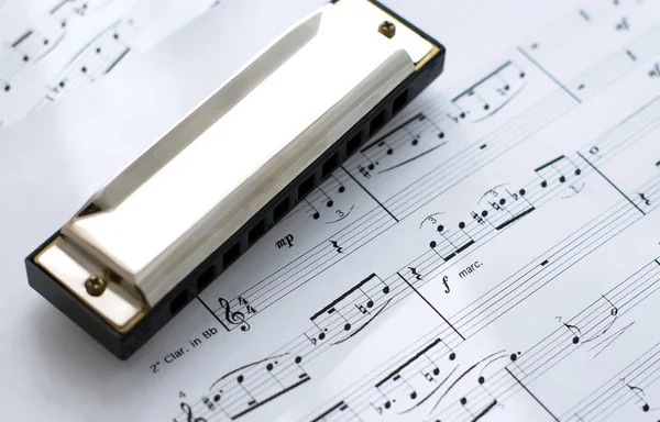 Harmonica on notes background — Stock Photo, Image