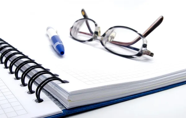 Notebook with pen and glasses Stock Picture