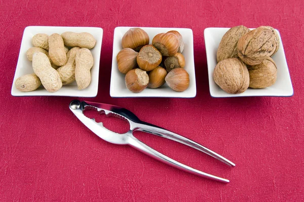 Walnuts, hazelnuts and peanuts in three bowls — Stock Photo, Image