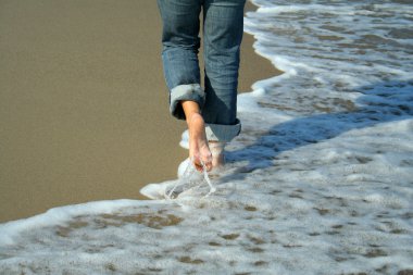 Woman walking on the beach clipart