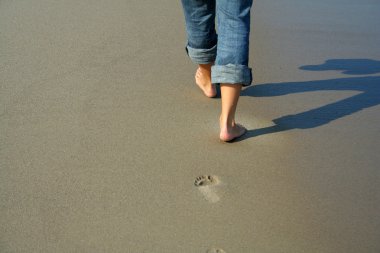 Woman walking on the beach clipart