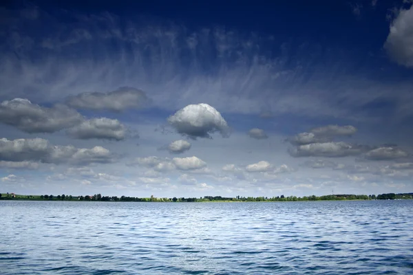 White clouds on the blue sky over the lake — Stock Photo, Image