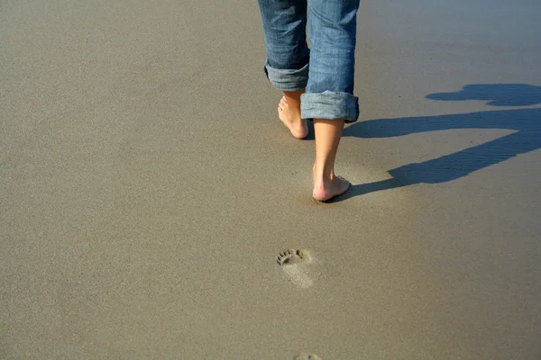 Vrouw die over het strand loopt — Stockfoto