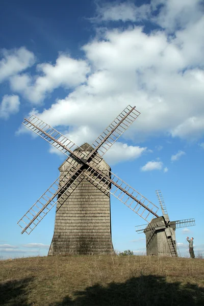 Větrné mlýny a malý muž — Stock fotografie