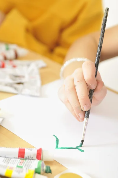 Девушка рисует на бумаге кистью — стоковое фото