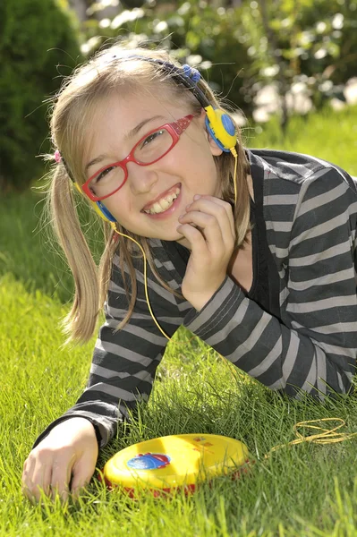 Pouco divertido menina ouvir música na cabeça — Fotografia de Stock