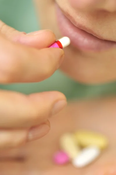 Close-up de jovem mulher colocando pílula em — Fotografia de Stock