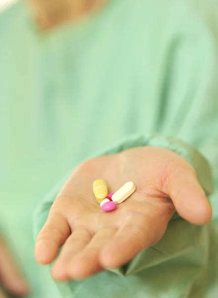 Mulher segura pílulas em uma mão — Fotografia de Stock