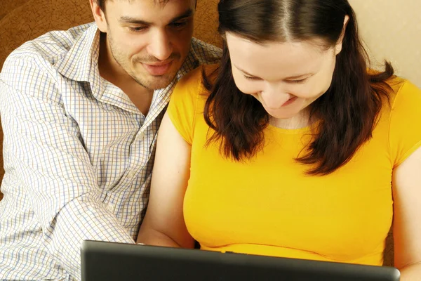 Mutlu genç bir çift bir dizüstü bilgisayar kullanarak — Stok fotoğraf