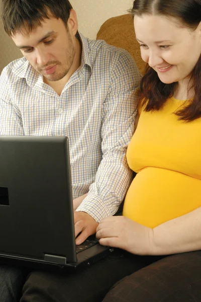 Man and pregnant woman with laptop — Stock Photo, Image
