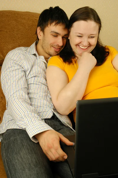 Donna incinta e il suo uomo con computer portatile — Foto Stock