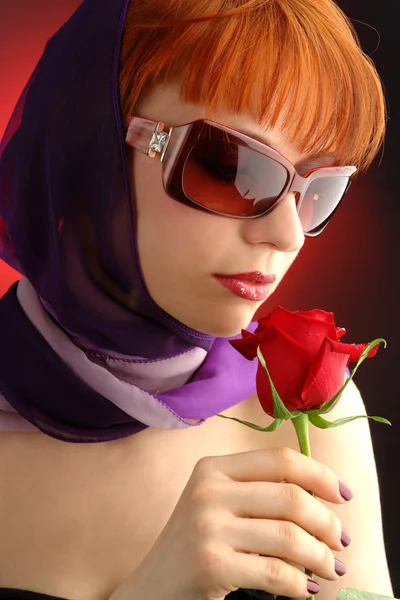 Рыжая женщина в солнечных очках с розой — стоковое фото