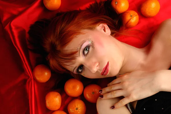 Young woman portrait with many oranges — Stock Photo, Image