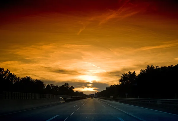 Autobahn vid solnedgången Royaltyfria Stockfoton