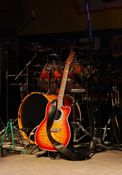 Акустическая гитара и барабаны на сцене — стоковое фото