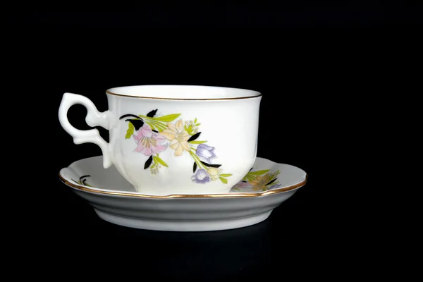 Ornate porcelain cup on black — Stock Photo, Image