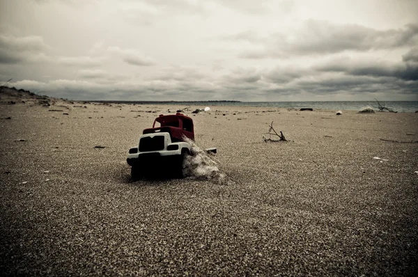 Speelgoedauto in zand — Stockfoto