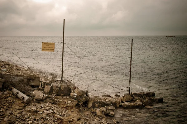 Zaunpfahl mit Stacheldraht an der Küste — Stockfoto