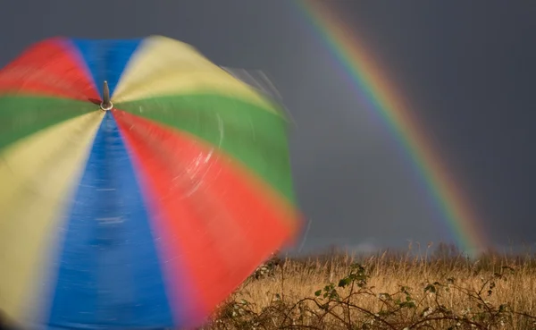 Spinning paraply och regnbåge Stockbild