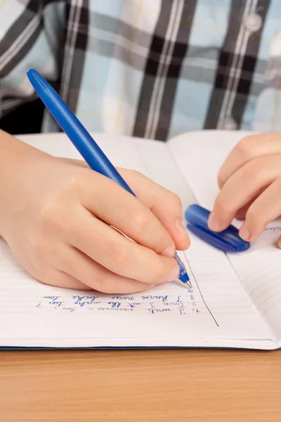 Anonym elev hand skriva läxor — Stockfoto