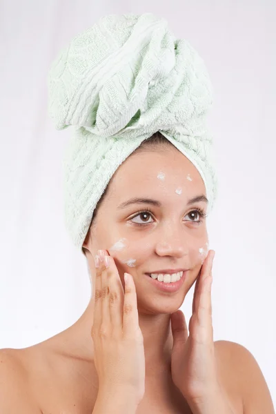 Giovane signora applicando crema sul viso — Foto Stock
