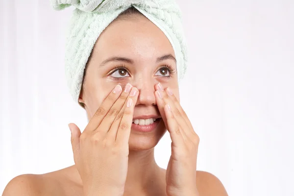 Giovane donna che applica la crema sul suo viso — Foto Stock