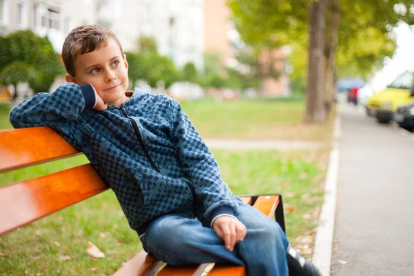 Enfant sur un banc dans un parc — Photo