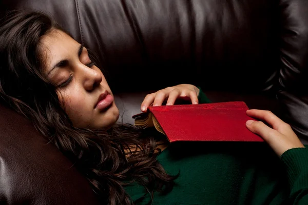 Jovem senhora dormindo no sofá com um livro — Fotografia de Stock