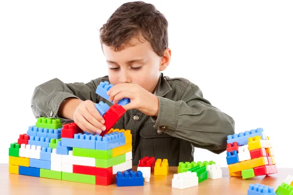 Мальчик играет с пластиковыми кубиками — стоковое фото