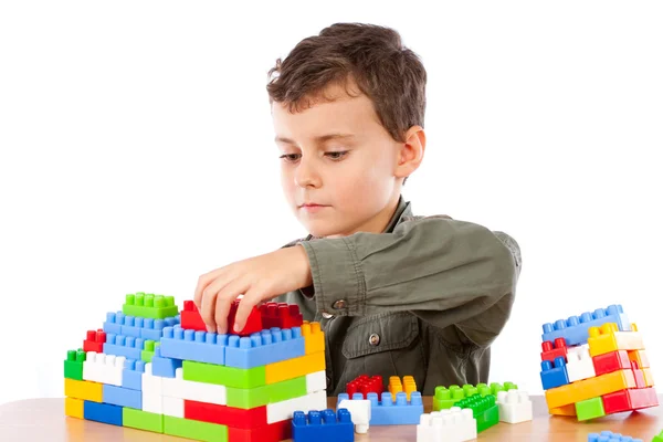 Маленький хлопчик грає з пластиковими кубиками — стокове фото