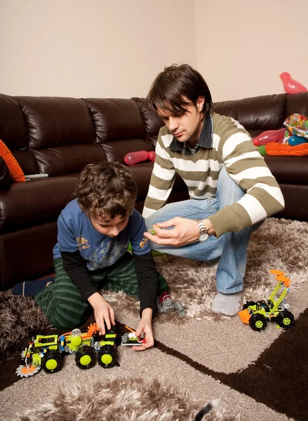 Brothers playing with plastic trucks — Stock Photo, Image