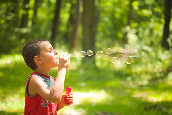 Lindo niño soplando burbujas de jabón —  Fotos de Stock