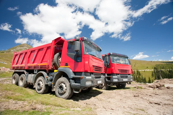 Two large red dump trucks — Stock Photo, Image