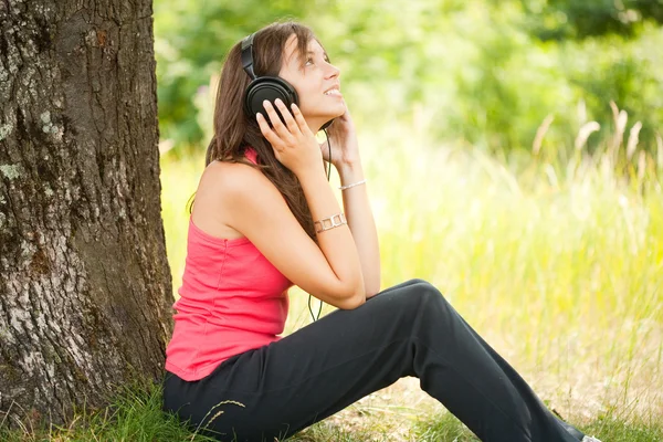 Ung kvinna med hörlurar utomhus — Stockfoto
