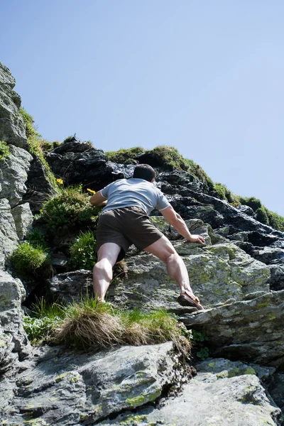 Сильный человек, взбирающийся на гору — стоковое фото