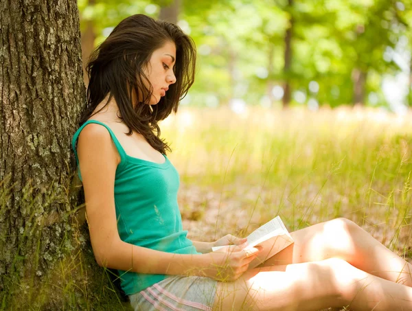 Μελαχρινή κοπέλα διαβάζοντας ένα βιβλίο σε εξωτερικούς χώρους — Φωτογραφία Αρχείου